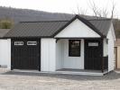 Custom 12x20 Victorian Building with Porch and with White LP Board N Batten Siding, Black Doors, Black Trim, and Black Metal Roof